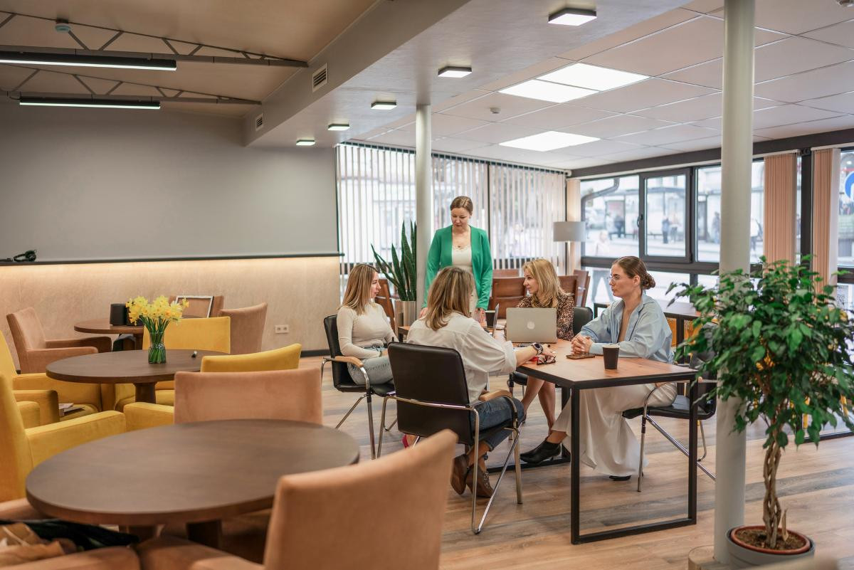 women meeting in modern stylish office lounge area discussing strategy