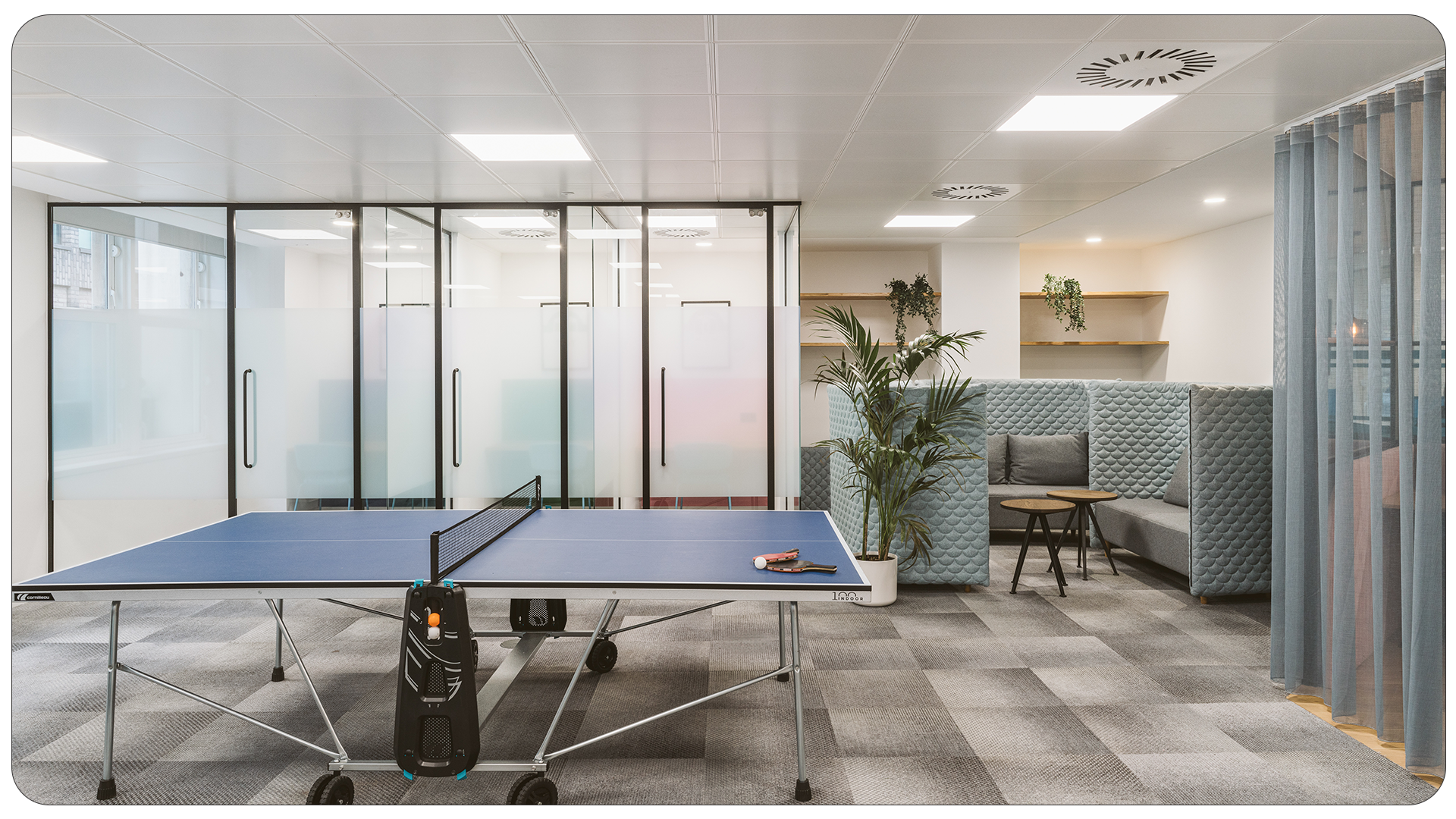 Office breakout area with ping pong table and enclosed seating with plants